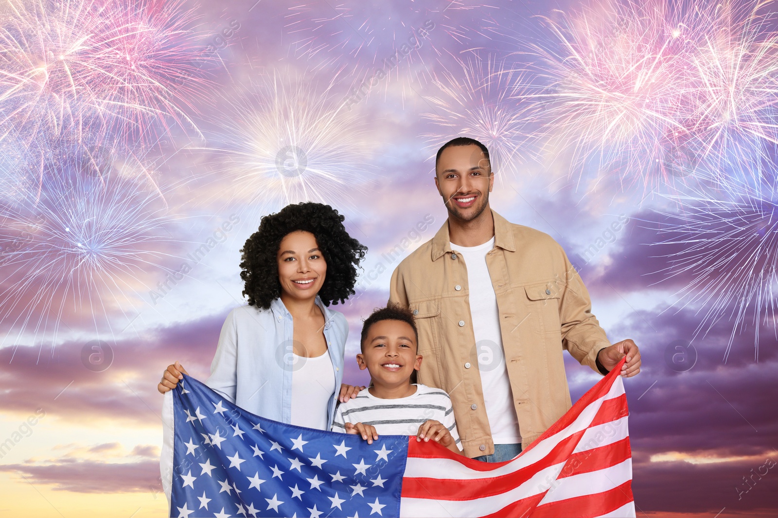 Image of 4th of July - Independence day of America. Happy family holding national flag of United States against sky with fireworks