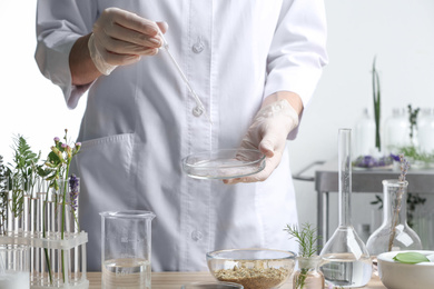 Scientist developing herbal cosmetic product in laboratory, closeup