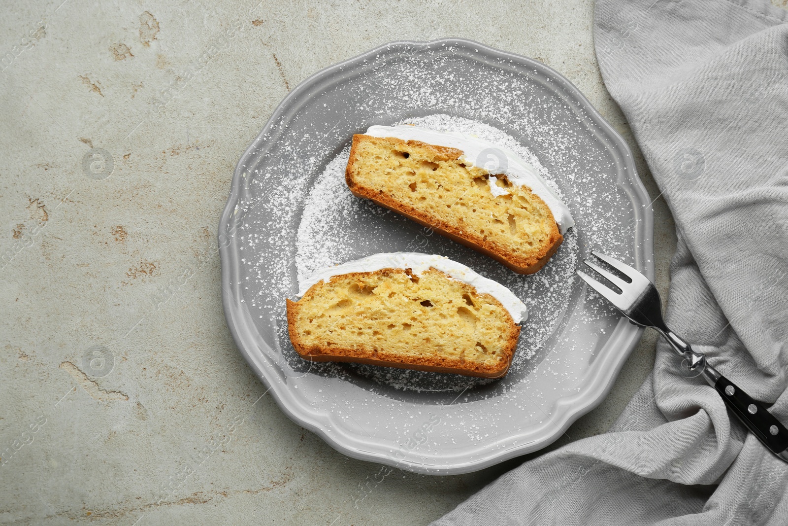 Photo of Pieces of delicious homemade yogurt cake with cream and powdered sugar on gray table, top view