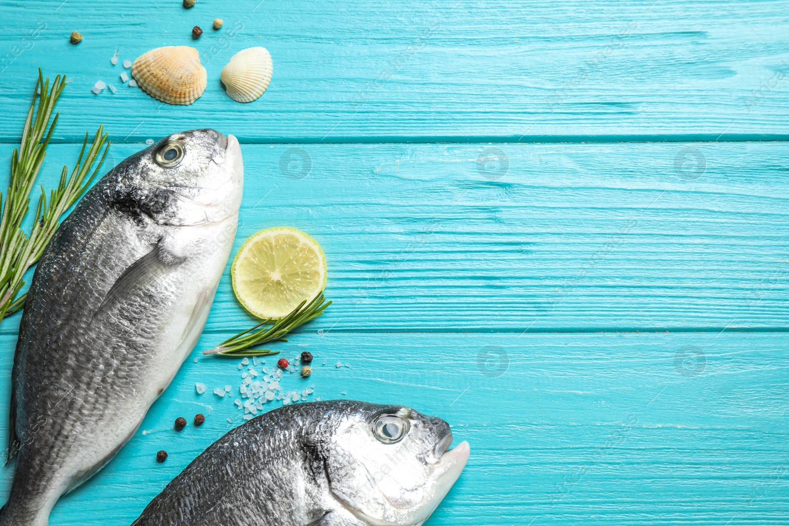 Photo of Flat lay composition with raw dorada fish on light blue wooden table, space for text