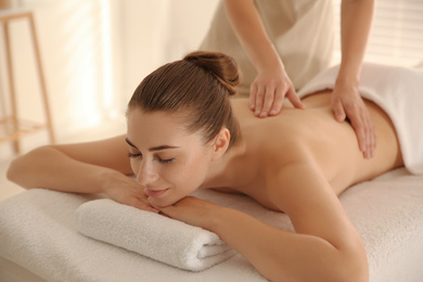 Young woman receiving back massage in spa salon