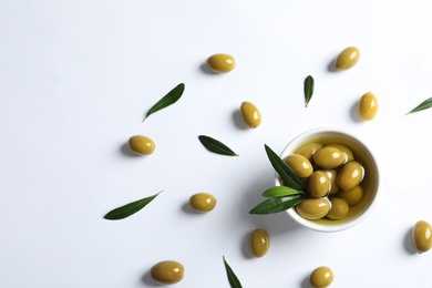 Flat lay composition with fresh olives in oil on white background