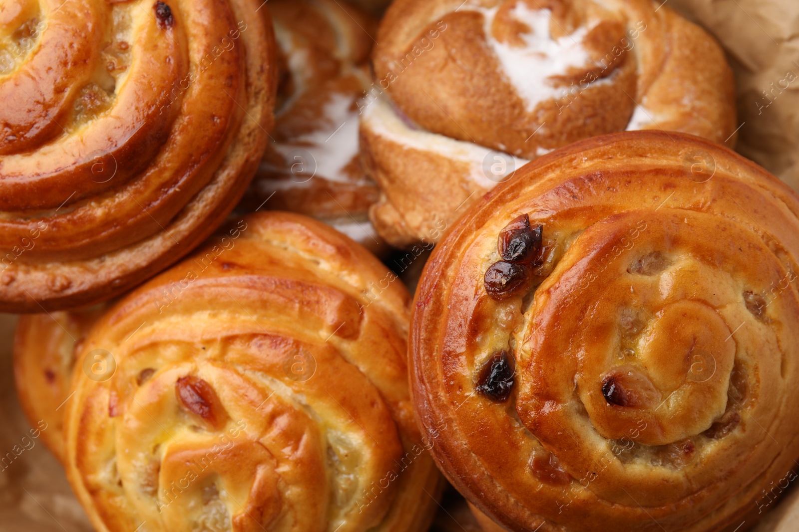 Photo of Delicious rolls with raisins and sugar powder as background, closeup. Sweet buns