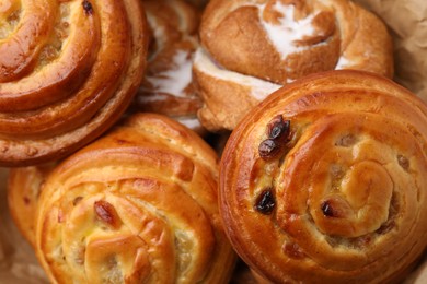 Photo of Delicious rolls with raisins and sugar powder as background, closeup. Sweet buns