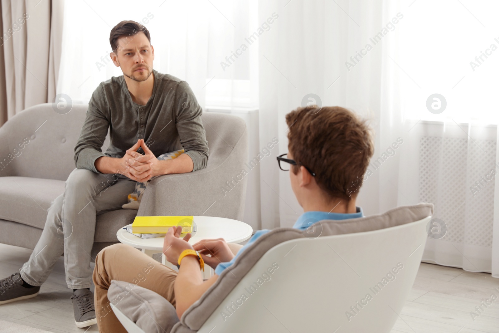 Photo of Strict father talking with his teenager son at home