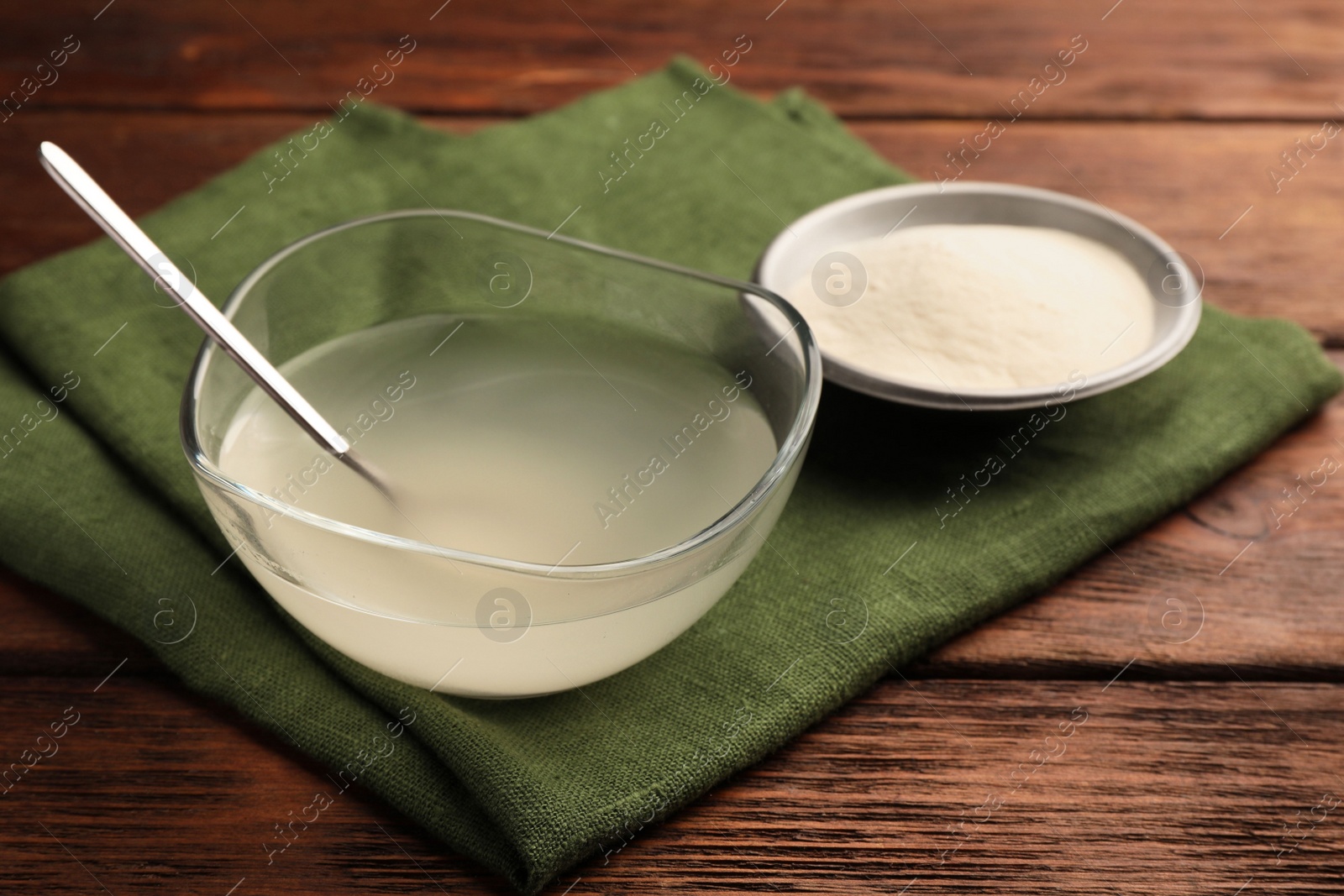 Photo of Agar-agar jelly and powder on wooden table