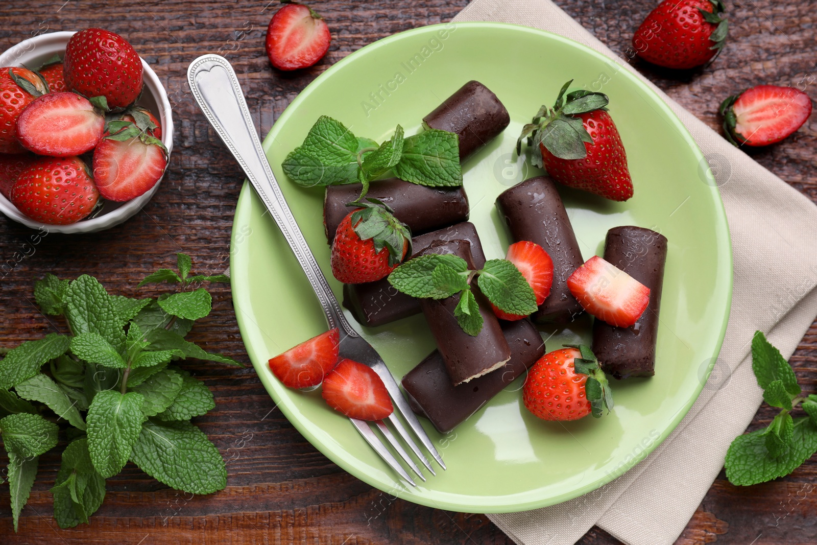 Photo of Delicious glazed curd snacks with fresh strawberries and mint on wooden table, flat lay