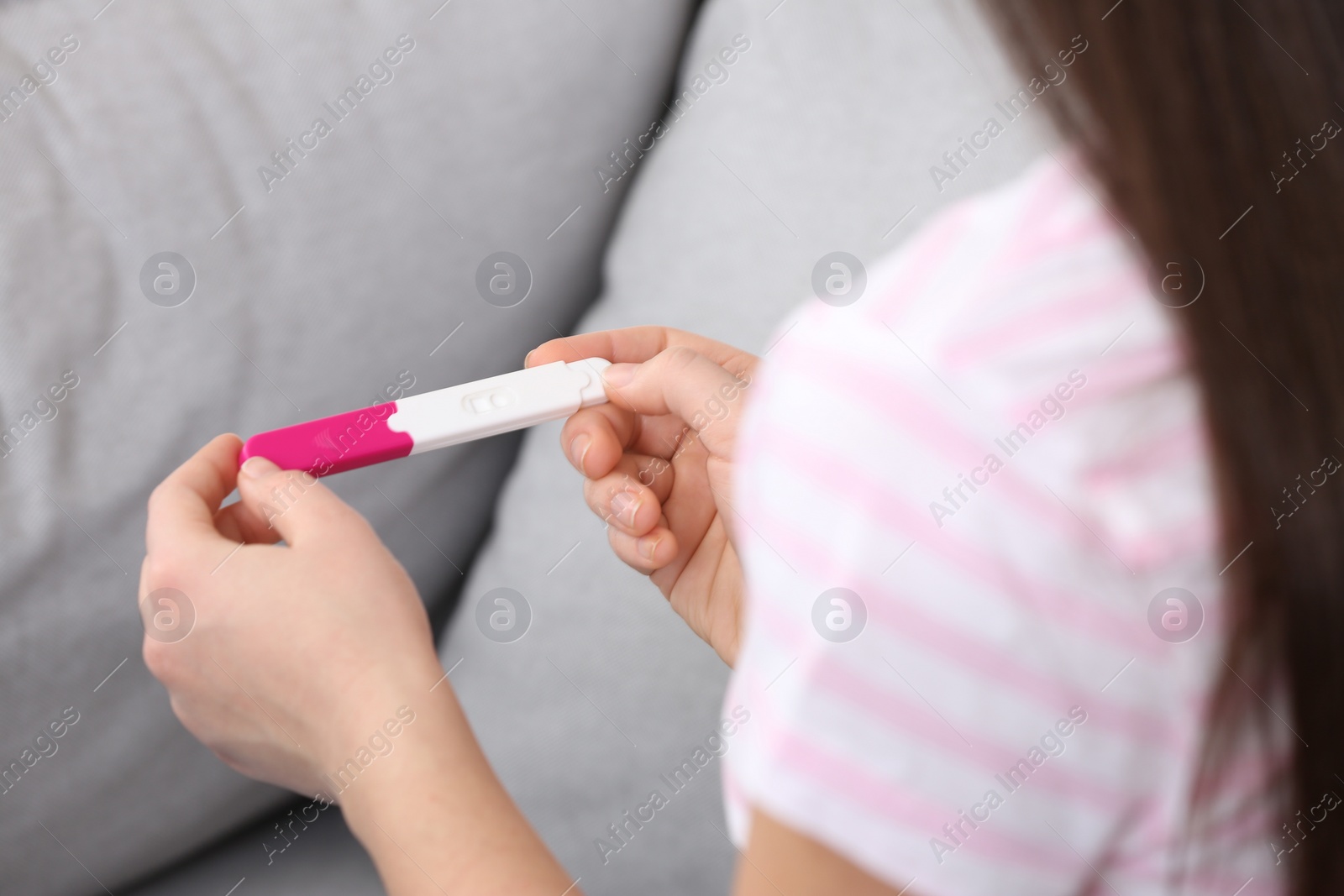 Photo of Young woman with pregnancy test indoors, closeup. Gynecology and childbirth