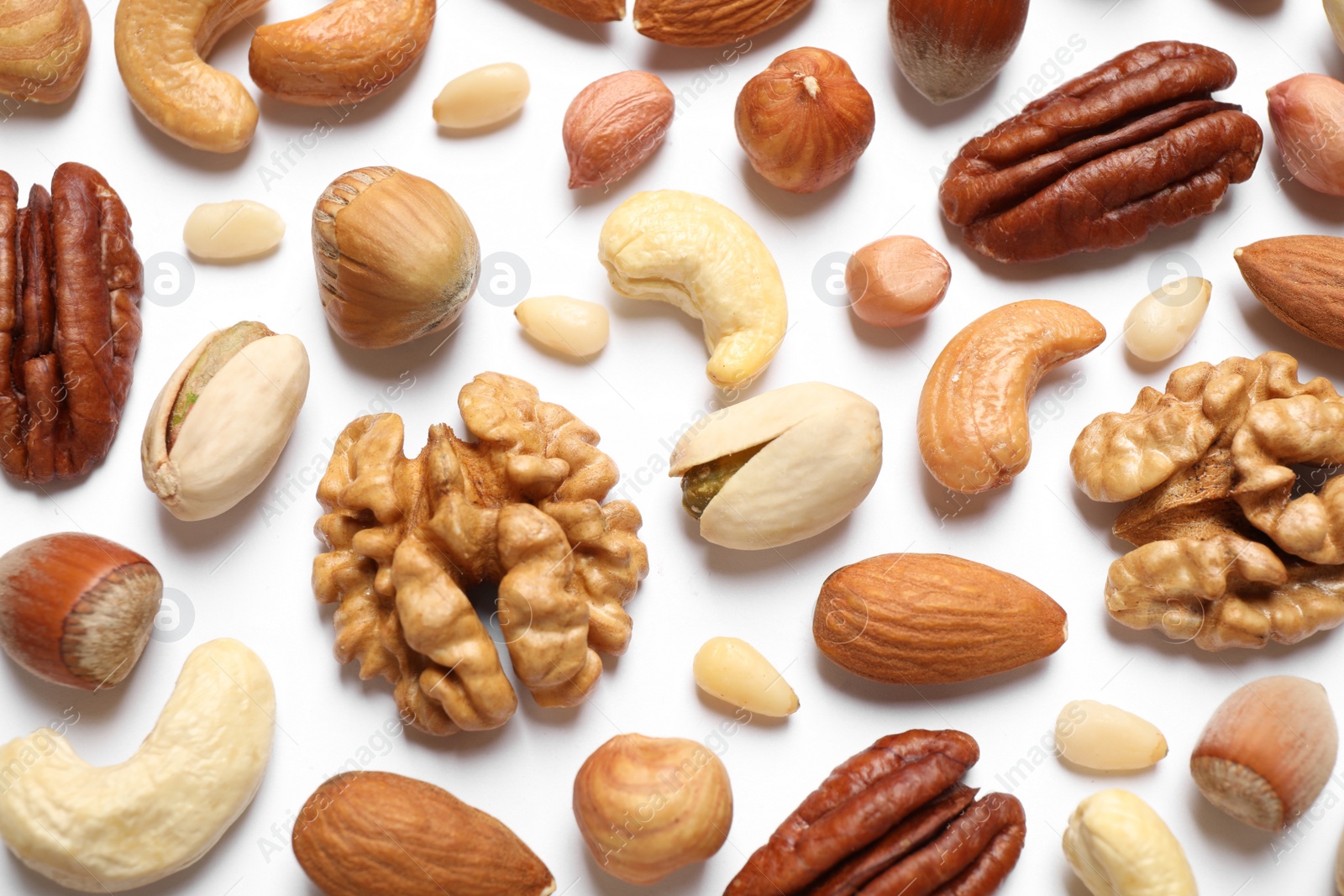 Photo of Different delicious nuts on white background, flat lay