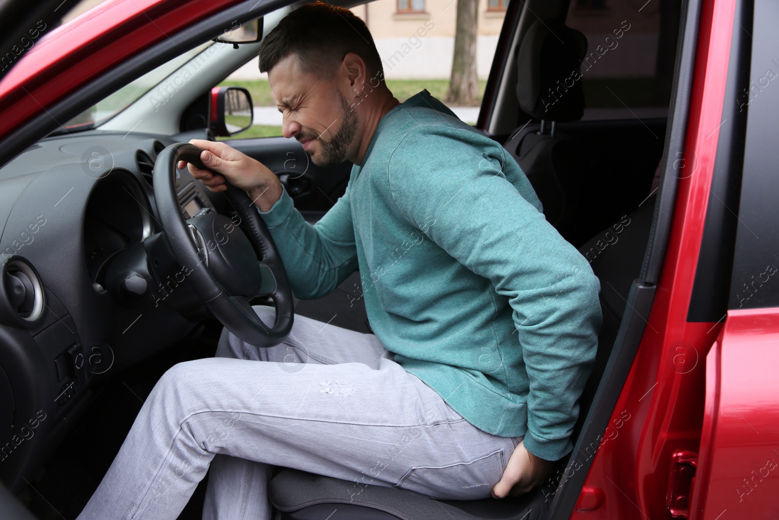 Photo of Man suffering from hemorrhoid pain in car