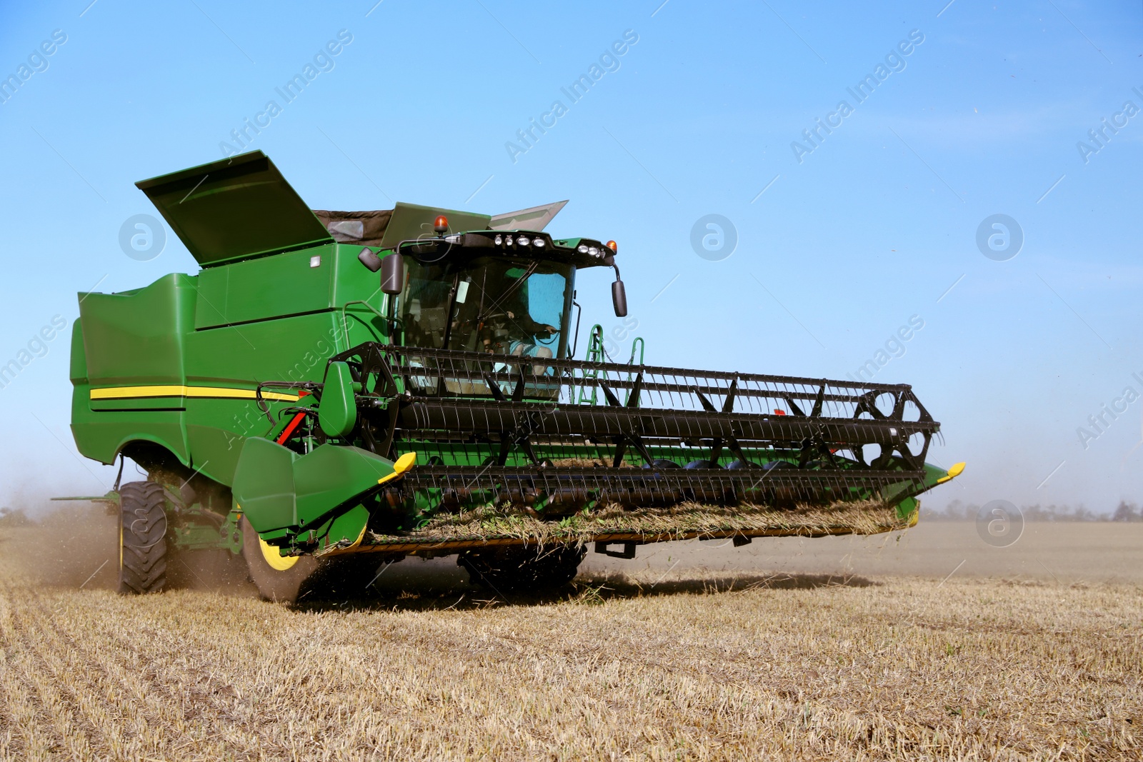 Photo of Modern combine harvester working in agricultural field