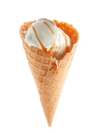 Photo of Delicious ice cream with caramel sauce in waffle cone on white background