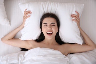 Photo of Young woman having orgasm in bed, top view