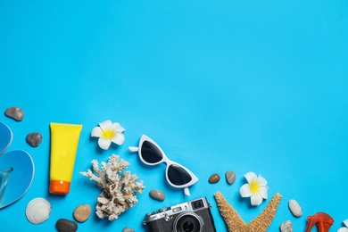 Flat lay composition with stylish beach accessories on light blue background, space for text