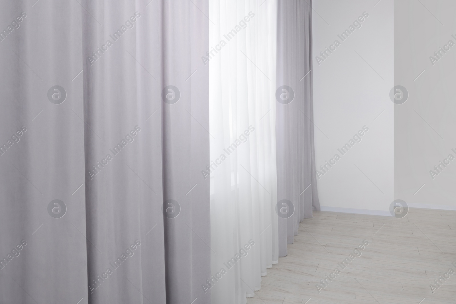 Photo of Light grey window curtains and white tulle indoors