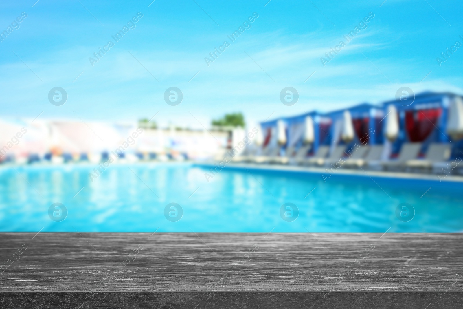 Image of Empty stone surface near outdoors swimming pool with clear water. Space for design
