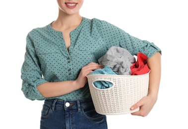 Photo of Happy young woman holding basket with laundry on white background