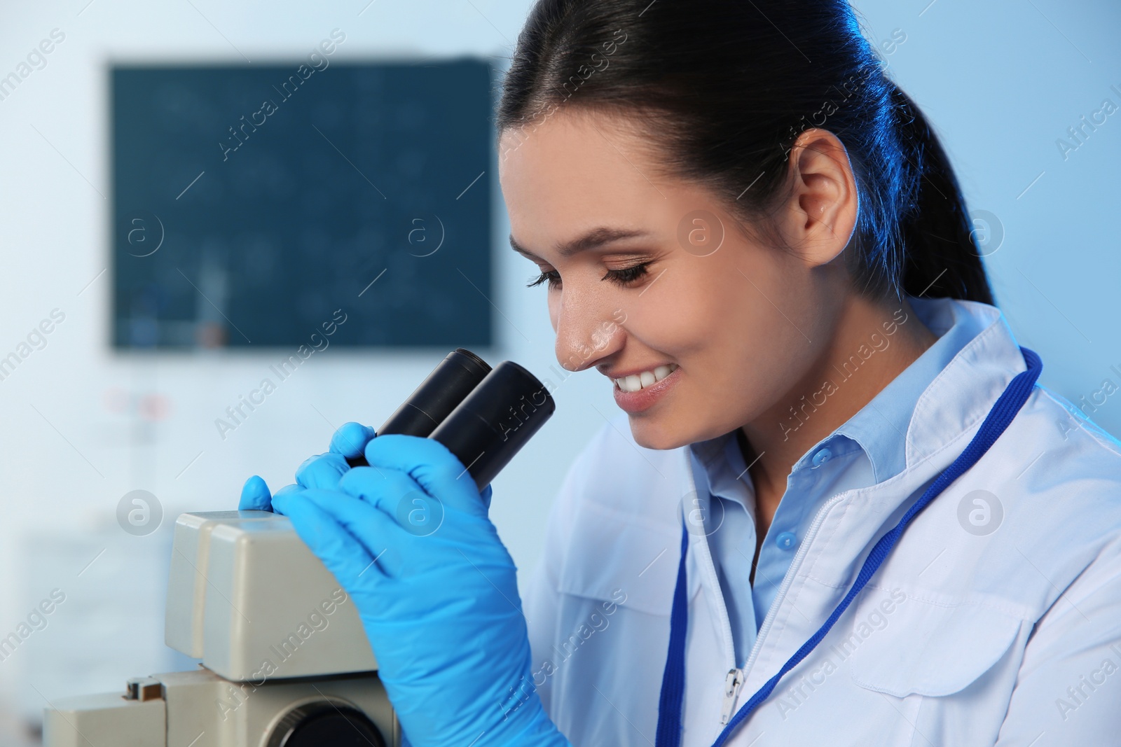 Photo of Female scientist using modern microscope in chemistry laboratory