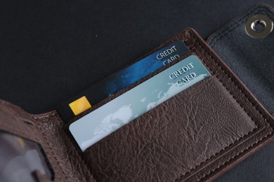 Credit cards in leather wallet on grey table