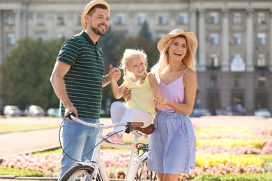 Photo of Happy family with bicycle outdoors on summer day