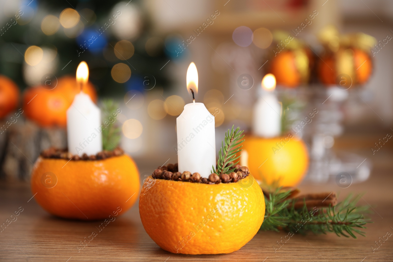 Photo of Burning candle in tangerine peel as holder on wooden table