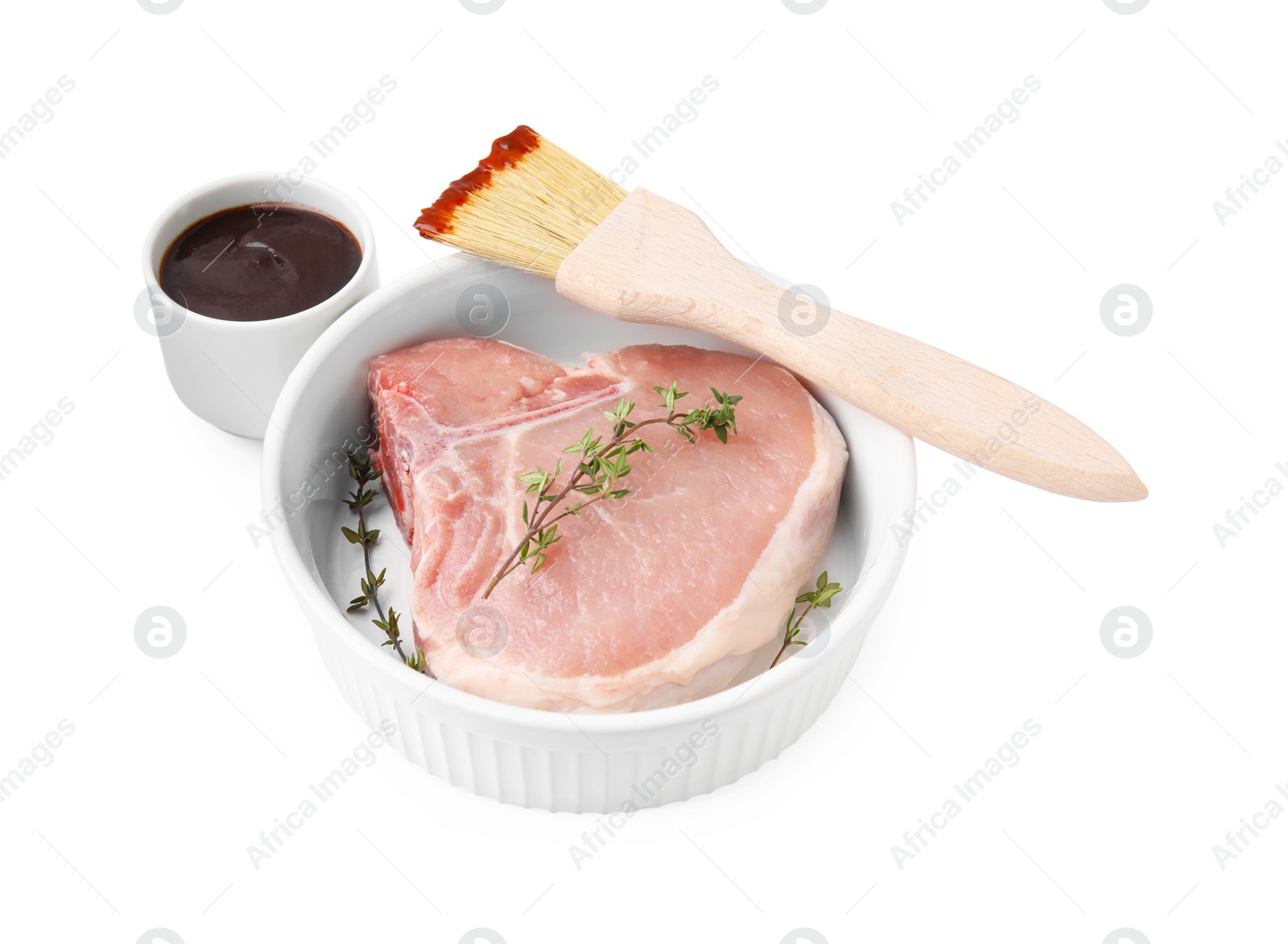 Photo of Raw meat, thyme and brush with marinade isolated on white