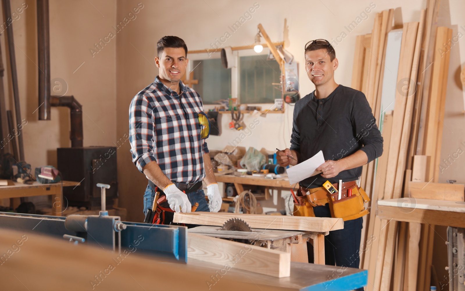 Photo of Professional carpenters working with draft in workshop