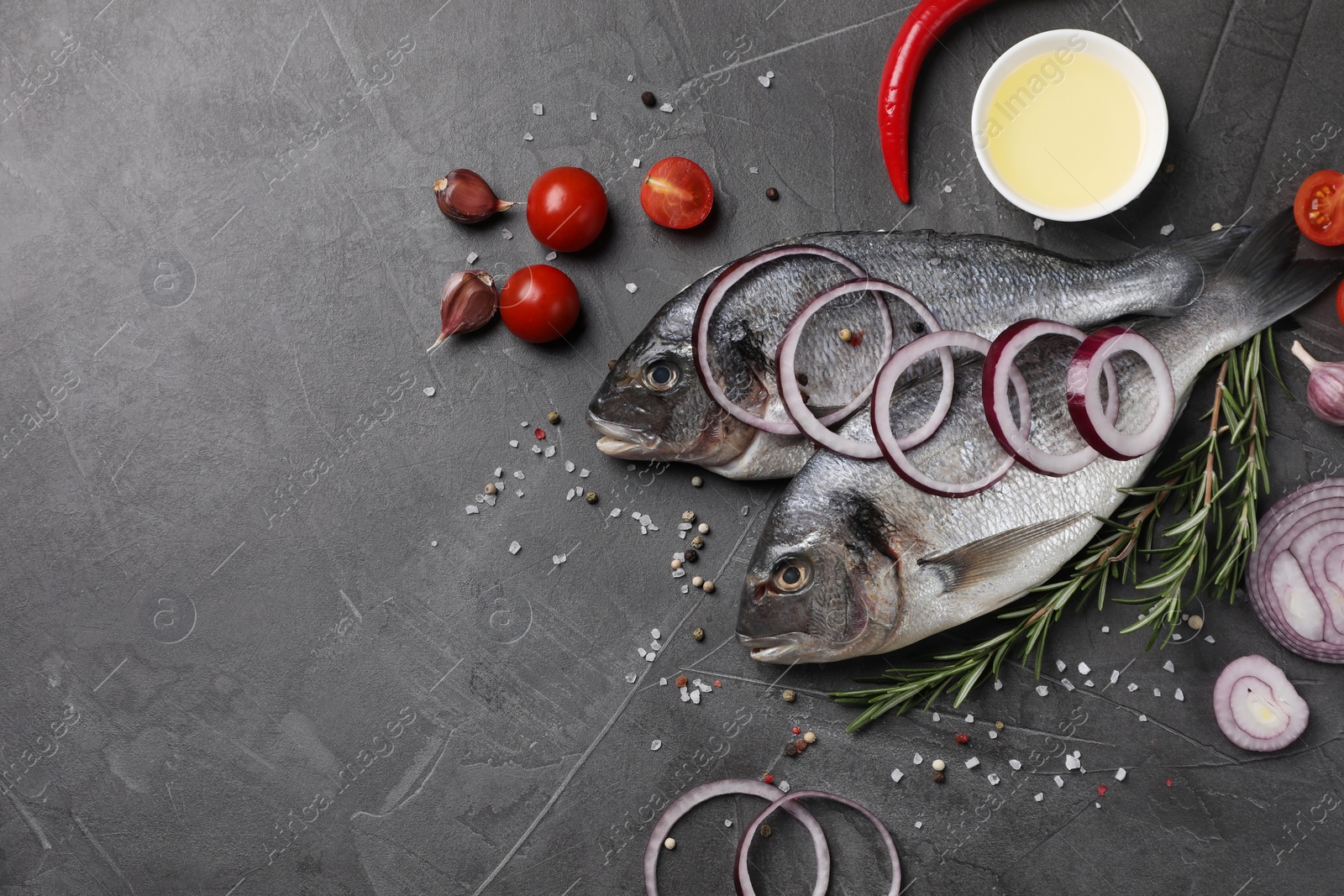 Photo of Fresh dorado fish and ingredients on grey table, flat lay. Space for text