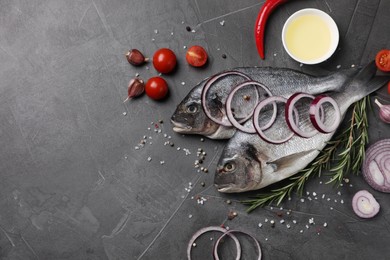 Fresh dorado fish and ingredients on grey table, flat lay. Space for text