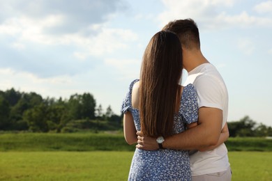 Photo of Romantic date. Couple spending time together outdoors, back view with space for text