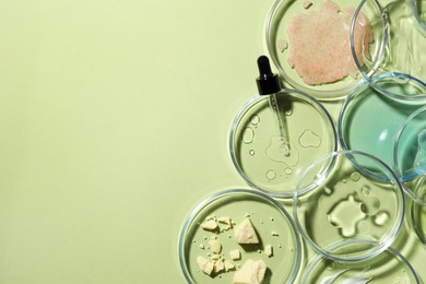 Photo of Flat lay composition with Petri dishes on light green background. Space for text