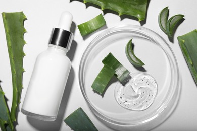 Photo of Flat lay composition with cosmetic products and cut aloe vera on white background