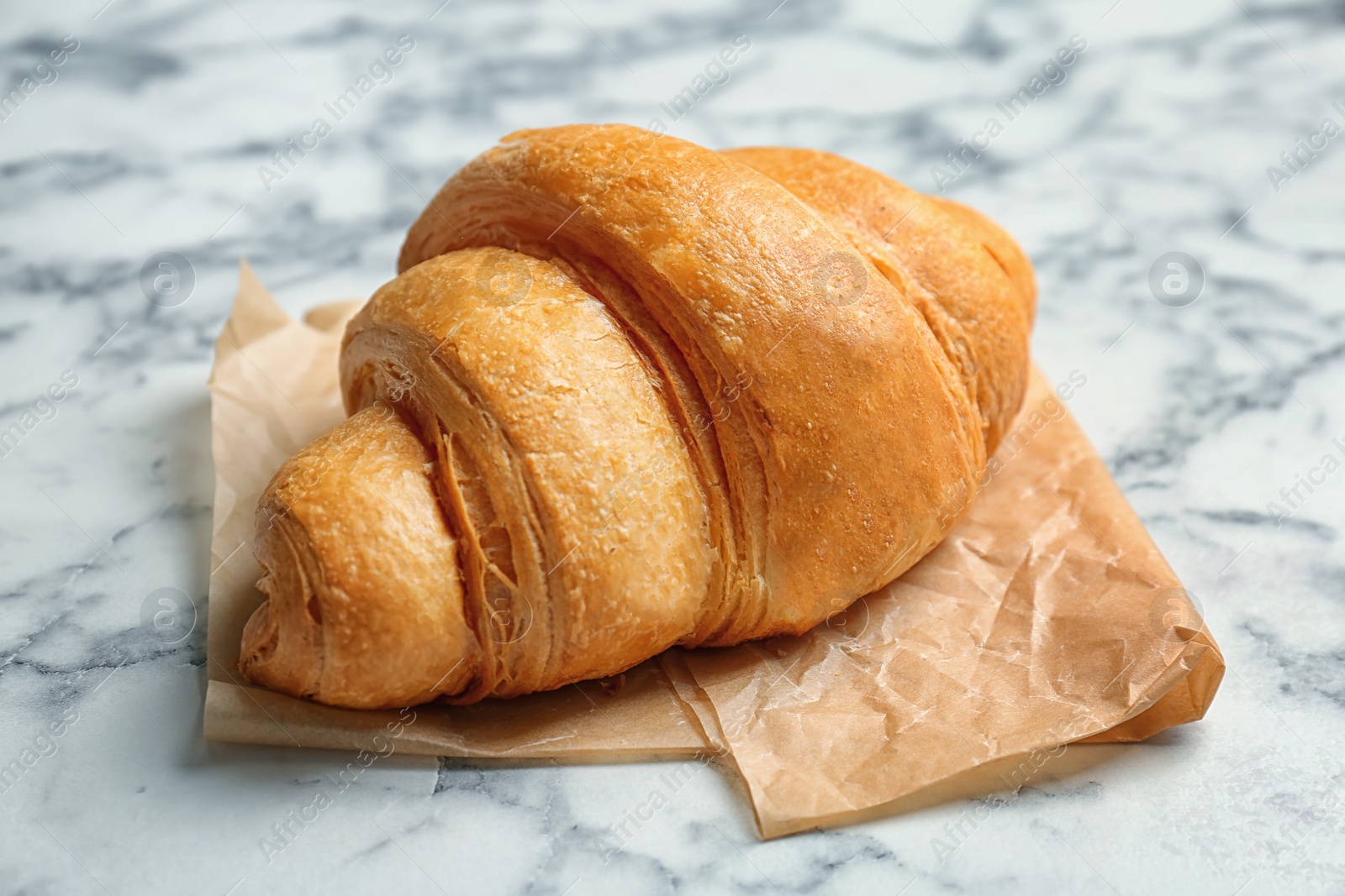 Photo of Tasty croissant on marble table