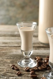 Coffee cream liqueur in glass and beans on wooden table