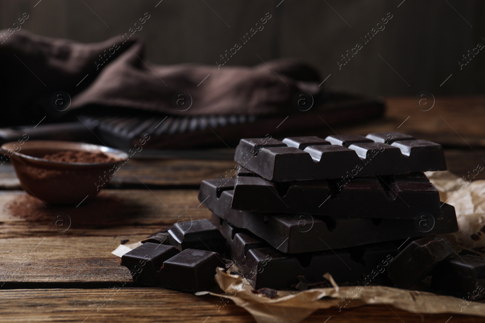 Photo of Tasty dark chocolate bars on wooden table