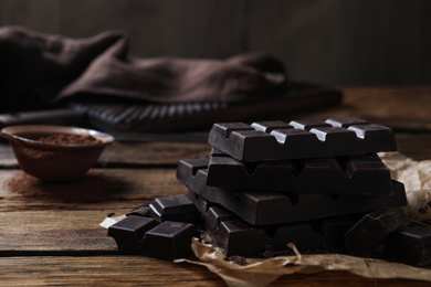 Tasty dark chocolate bars on wooden table