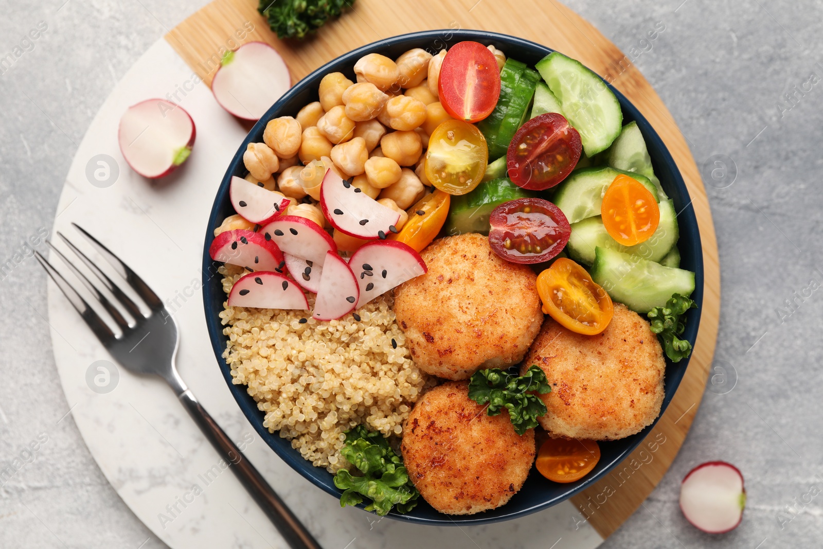 Photo of Delicious vegan bowl with chickpeas, cutlets and radish on grey table, flat lay