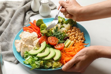 Photo of Balanced diet and healthy foods. Woman eating dinner at white table, closeup