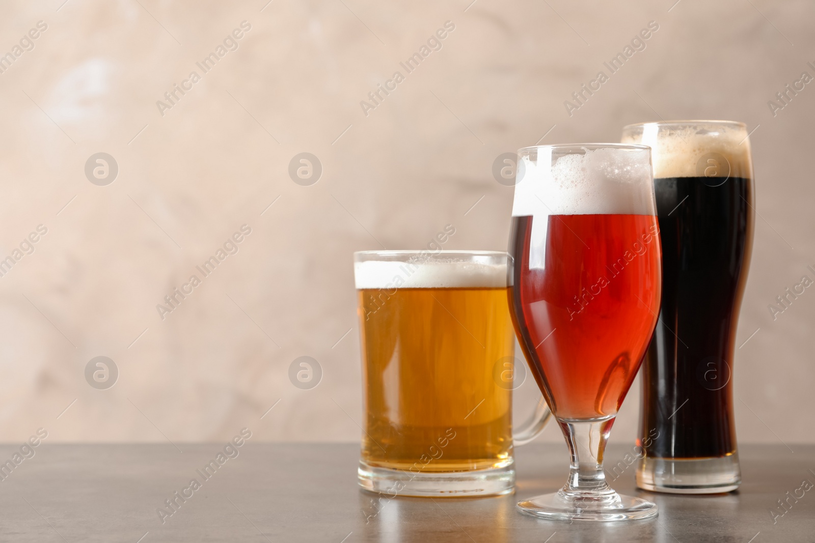 Photo of Glasses with different types of cold tasty beer on table