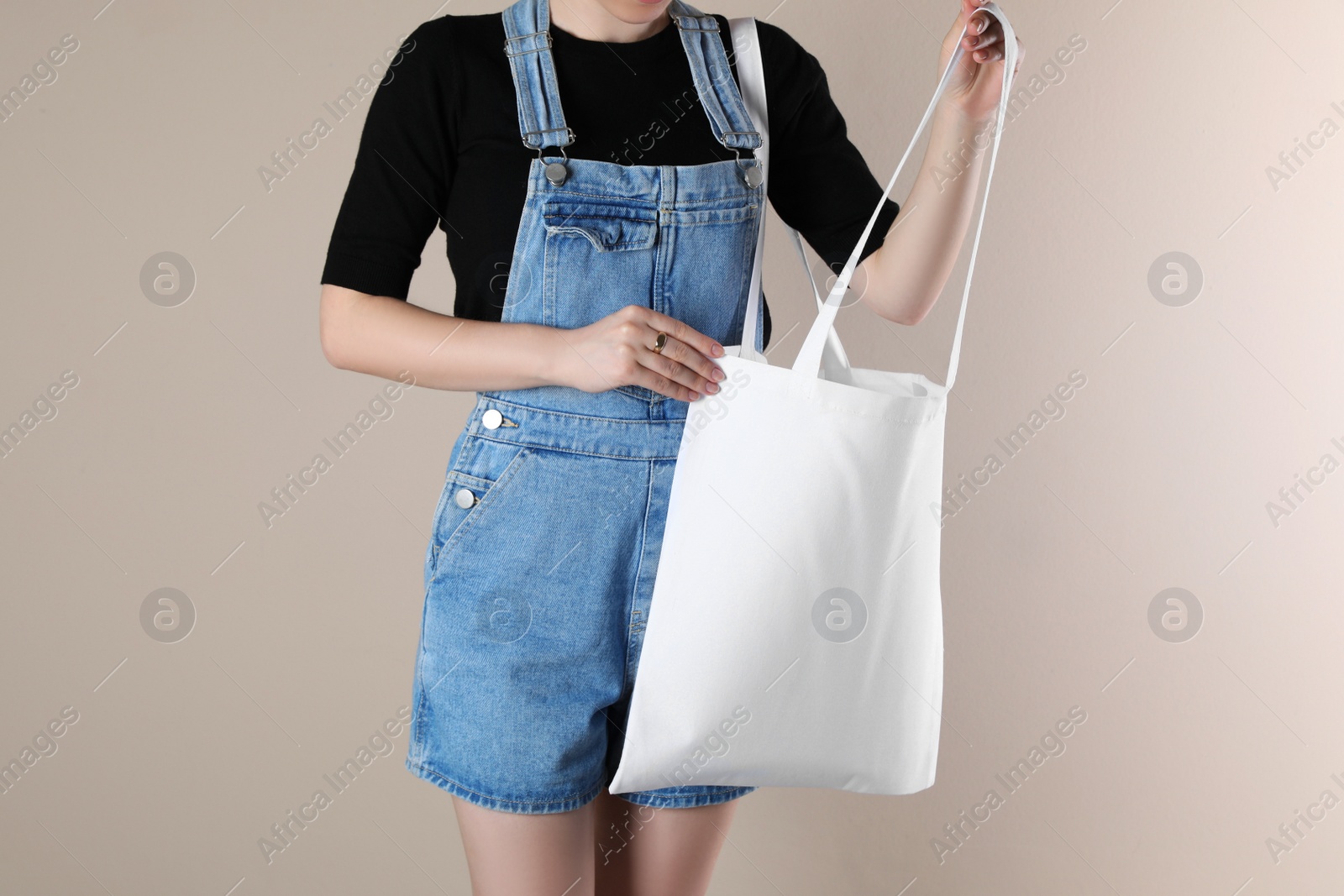 Photo of Woman with textile bag on beige background, closeup. Space for design
