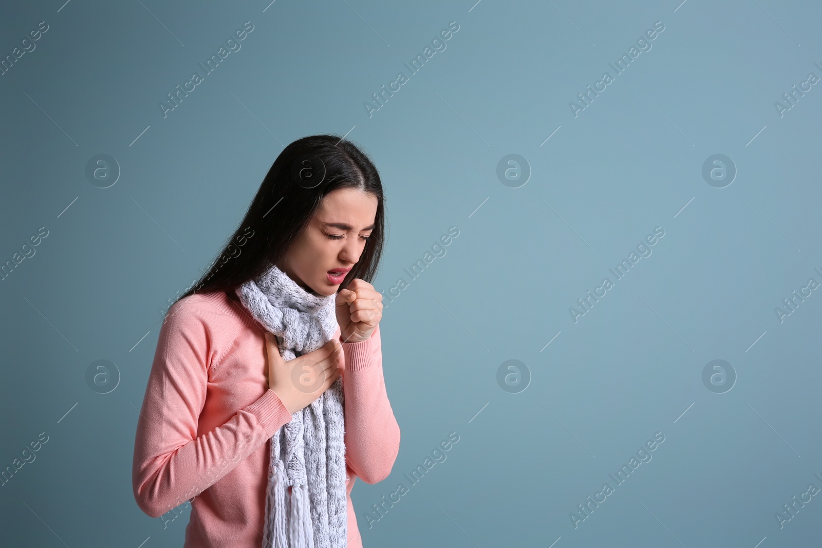 Photo of Young woman coughing on color background