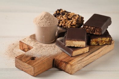 Photo of Different tasty energy bars and protein powder on white wooden table