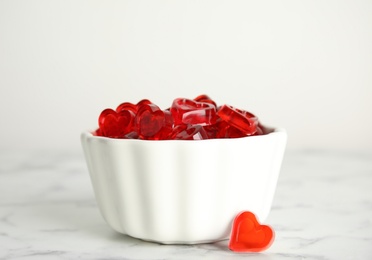 Photo of Sweet heart shaped jelly candies on white marble table