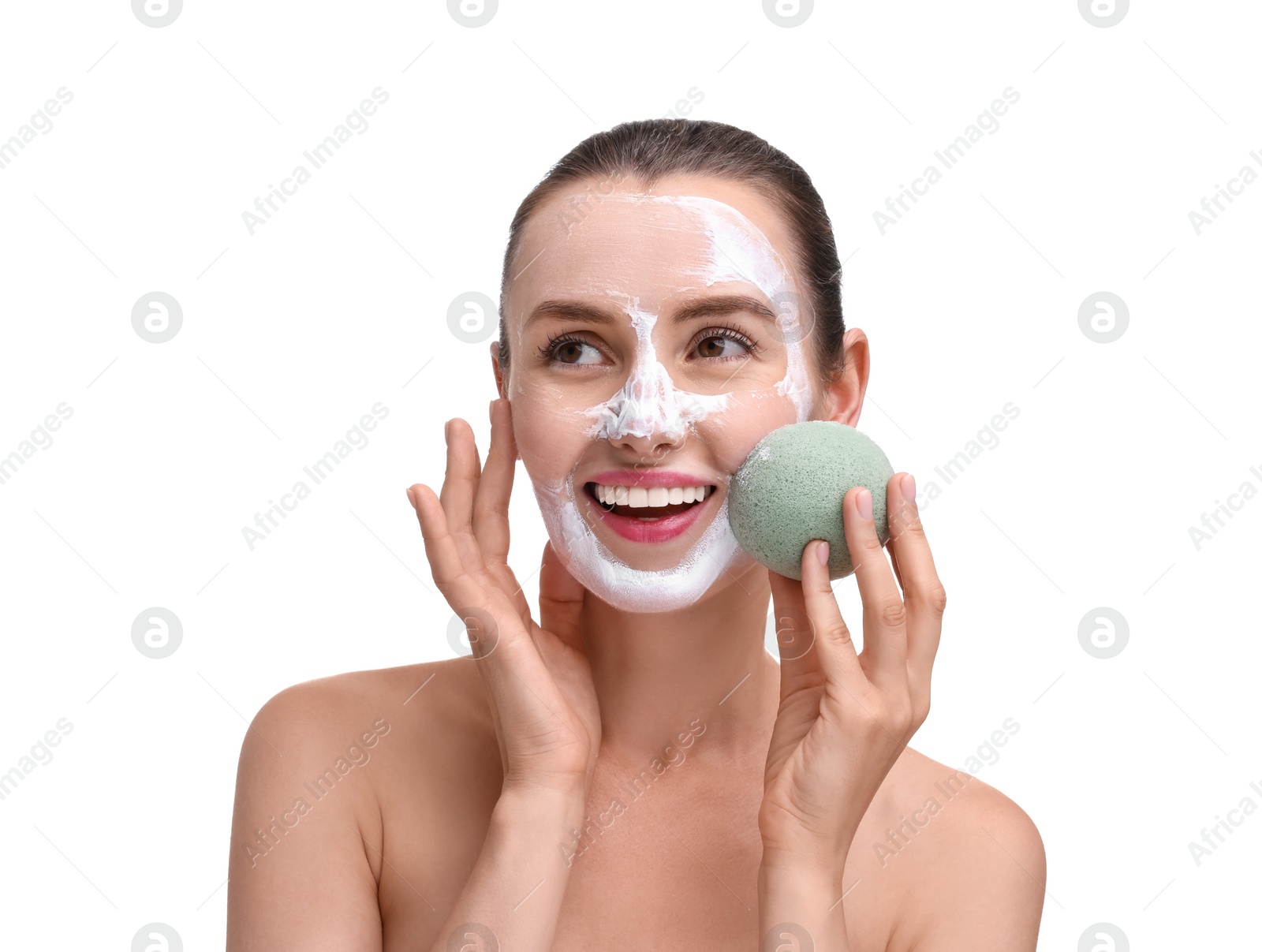 Photo of Happy young woman washing off face mask with sponge on white background