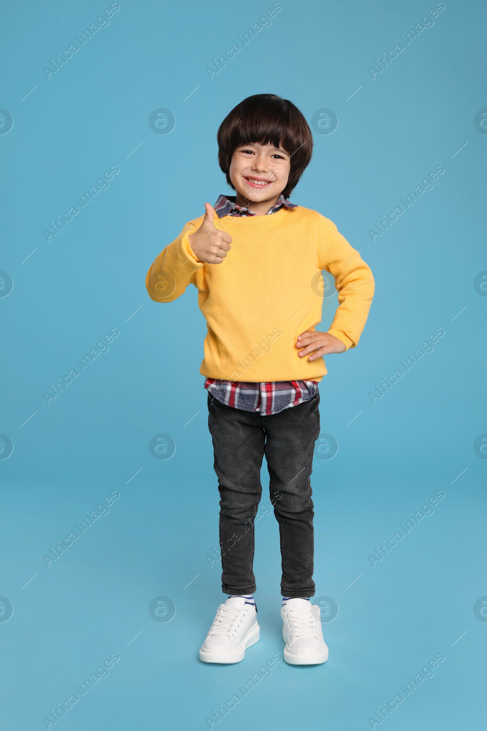 Photo of Full length portrait of cute little boy on light blue background