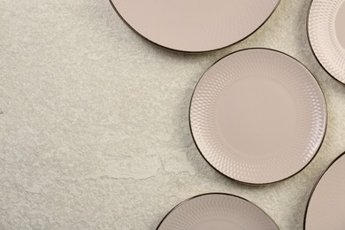 Photo of Beautiful ceramic plates on beige table, flat lay. Space for text