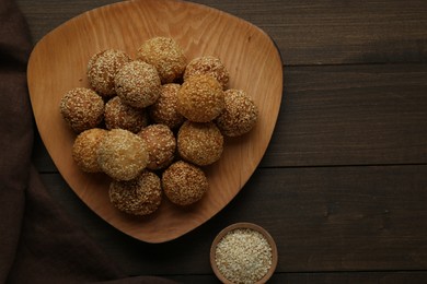 Photo of Delicious sesame balls on wooden table, flat lay. Space for text