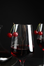Delicious cherry wine with ripe juicy berries on black background
