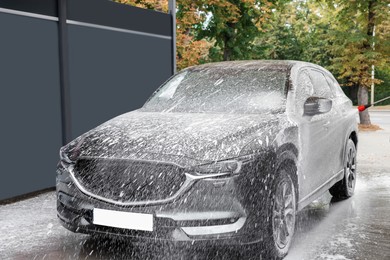 Washing auto with high pressure water jet at outdoor car wash