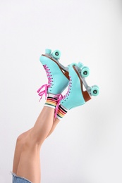 Photo of Young woman with retro roller skates on white background, closeup